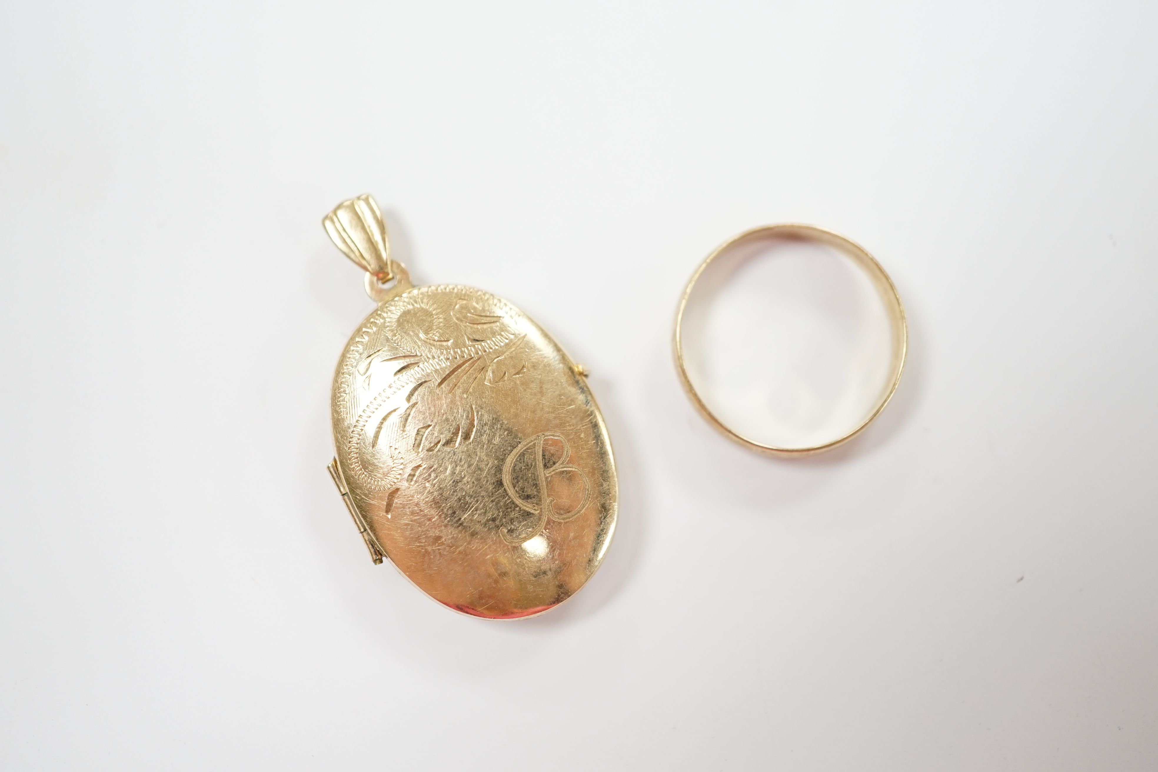 A 9ct gold wedding band and a modern 9ct gold oval locket